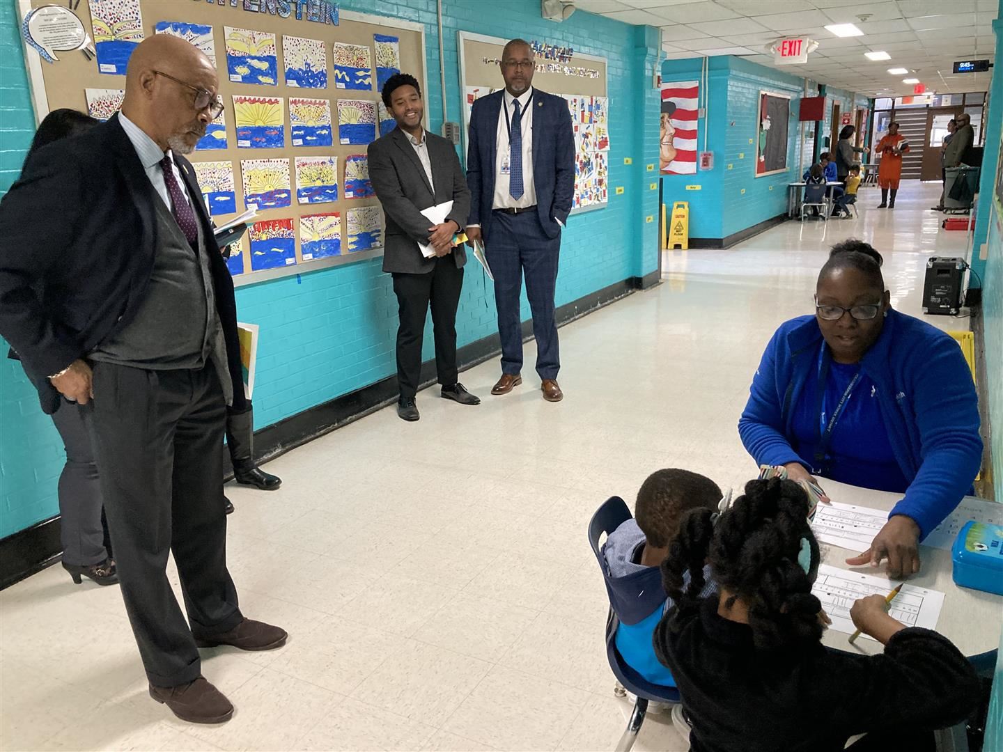 Administrators observe a tutoring session with two students.